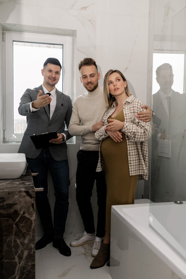 Coto de Caza real estate companies agent showing a bathroom in a new house to international couple