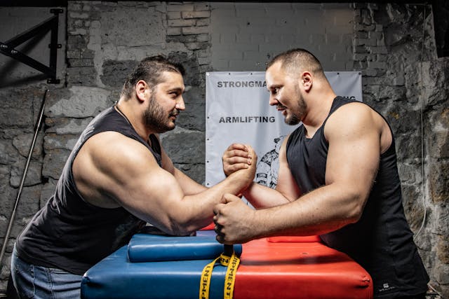 men arm wrestling at table